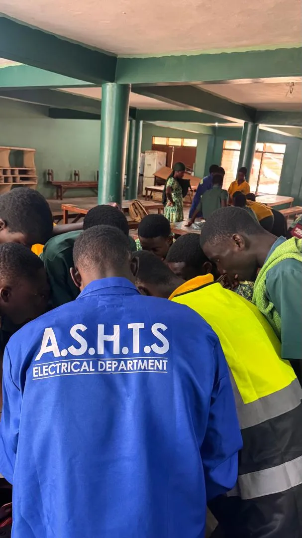 Action SHTS Electrical Department students in workshop overalls and hi-vis vests at a practical session